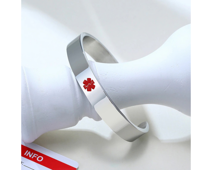 Silver medical alert bracelet with red enamel medical symbol on front.
